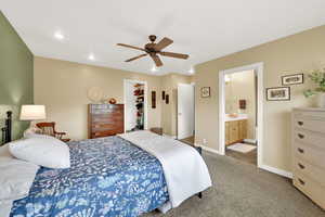 Bedroom featuring a spacious closet, light carpet, a ceiling fan, ensuite bath, and recessed lighting