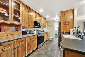 Kitchen featuring stainless steel appliances, glass insert cabinets, and recessed lighting