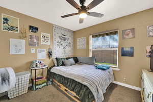 Carpeted bedroom with baseboards and ceiling fan
