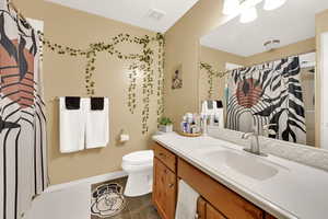 Bathroom featuring vanity, dark tile patterned floors, and a shower with curtain