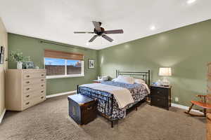 Carpeted bedroom featuring baseboards and ceiling fan