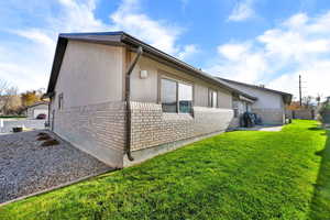 View of side of home with brick siding, stucco siding, and a patio area