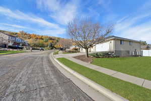 View of asphalt road with sidewalks, curbs, and a residential view