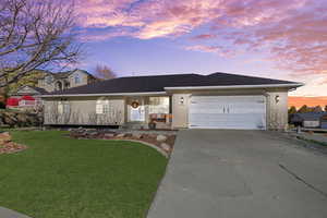 Ranch-style house with concrete driveway, a porch, a yard, brick siding, and a garage