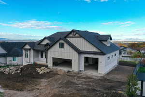 View of front of house with board and batten siding, a shingled roof, a mountain view, and a garage