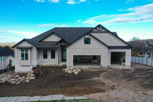View of front of property featuring board and batten siding, a shingled roof, a porch, driveway, and a garage