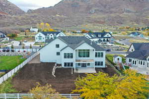 Back of house featuring a patio, a mountain view, a fenced backyard, and a residential view
