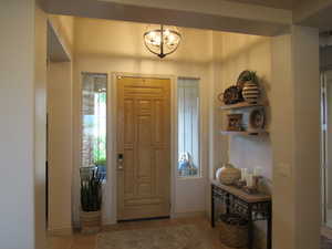 Entryway featuring light wood-style floors and a chandelier