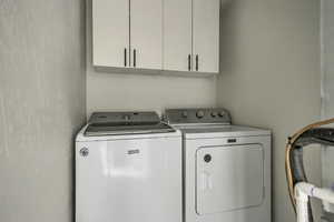 Laundry area featuring cabinet space and washer and clothes dryer