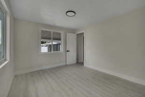 Spare room featuring light wood finished floors and baseboards