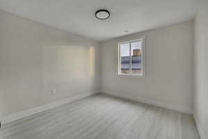 Spare room with light wood-style floors and baseboards