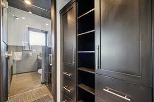 Bathroom with light tile patterned floors, a shower with shower door, and a closet