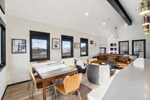 Dining area featuring light wood-style floors, beamed ceiling, recessed lighting, and high vaulted ceiling