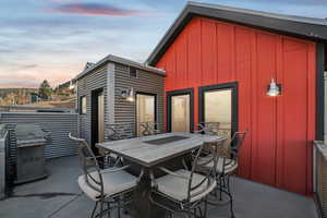 Patio terrace at dusk featuring outdoor dining space and area for grilling