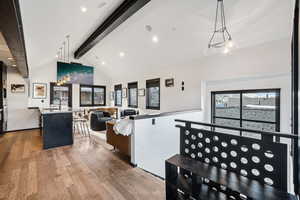 Living area featuring beamed ceiling, light wood finished floors, healthy amount of natural light, high vaulted ceiling, and recessed lighting