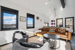 Living area featuring high vaulted ceiling, beam ceiling, and wood finished floors