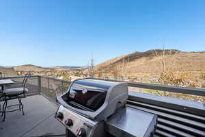 Balcony with a mountain view and area for grilling