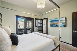 Bedroom with light wood-style floors, french doors, and access to exterior