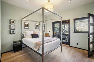 Bedroom featuring french doors, wood finished floors, and recessed lighting