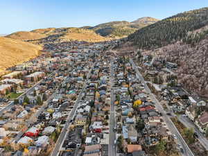 Aerial view of property and surrounding area with nearby suburban area and a mountain backdrop