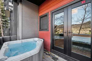 Wooden deck with french doors and a hot tub