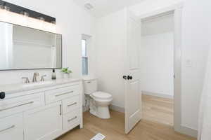 Bathroom featuring light wood-style floors, vanity, and curtained shower