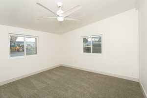 Spare room with lofted ceiling, carpet floors, a textured ceiling, and a ceiling fan