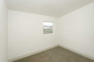 Carpeted empty room featuring baseboards