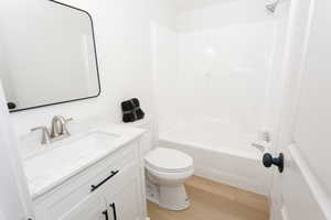 Full bathroom with light wood-style floors, tub / shower combination, and vanity
