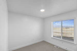 Empty room with carpet floors and baseboards