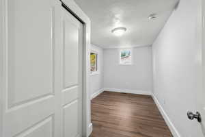 Spare room with a textured ceiling, dark wood-style floors, and a smoke detector