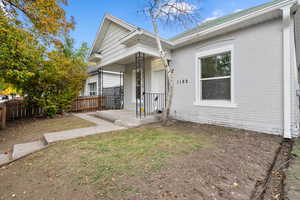 View of front of home with brick siding and a porch