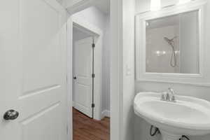 Bathroom featuring dark wood-style floors and a shower