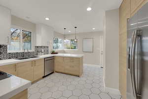 Kitchen with modern cabinets, appliances with stainless steel finishes, modern cabinets, a peninsula, and recessed lighting