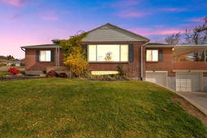 Single story home with driveway, brick siding, a front yard, and an attached garage