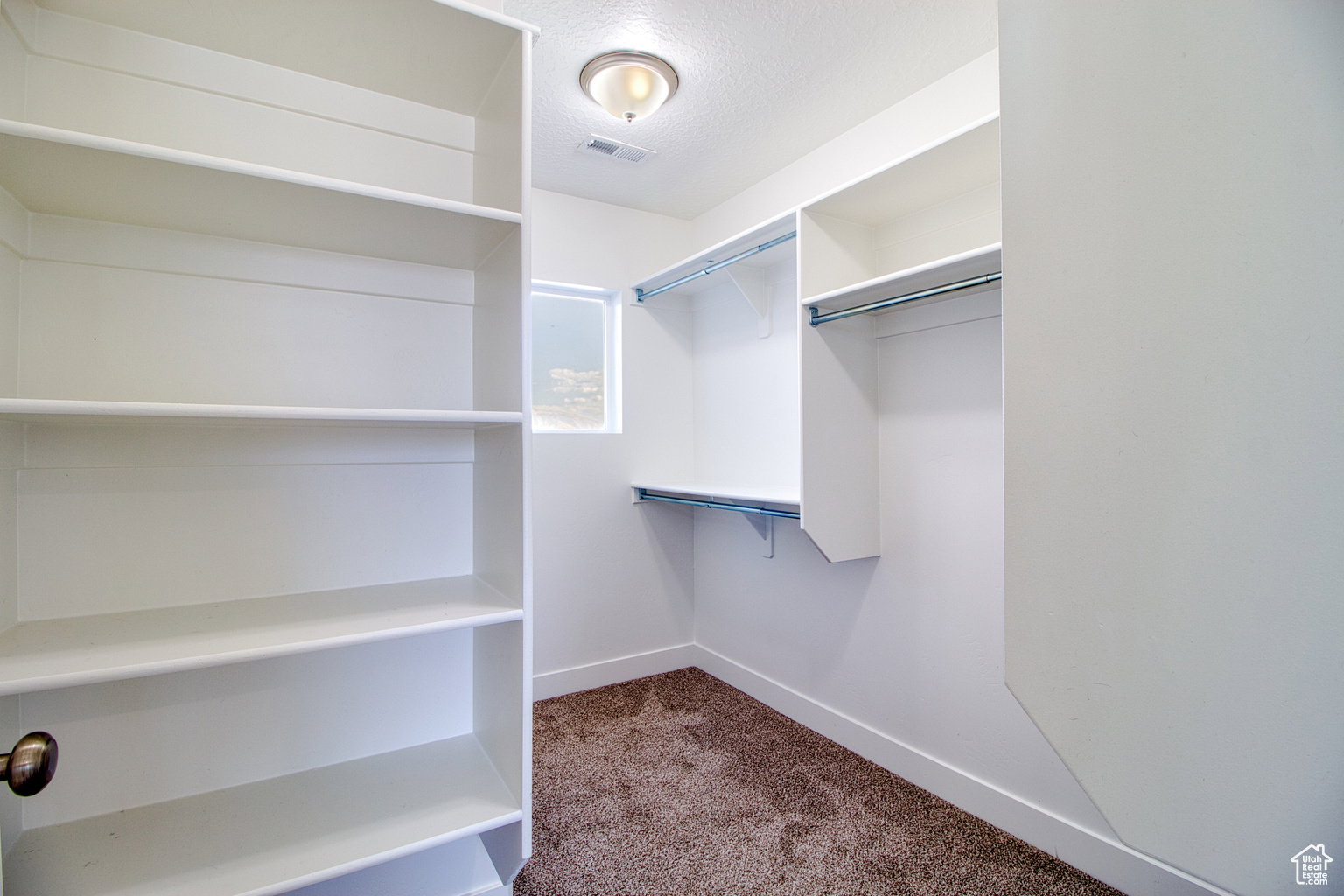 Walk in closet featuring dark carpet