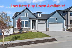 Modern inspired farmhouse featuring stone siding, driveway, board and batten siding, and a garage