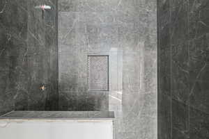 Full bath with a marble finish shower
