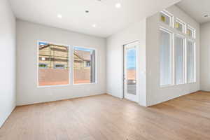 Spare room featuring healthy amount of natural light, light wood finished floors, and recessed lighting