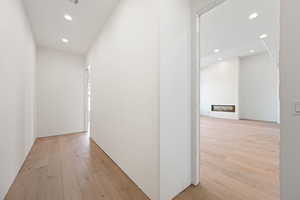 Hallway featuring light wood finished floors and recessed lighting