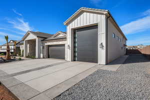 View of front facade featuring a garage, board and batten siding, and concrete driveway