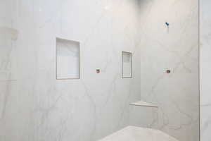 Bathroom featuring a marble finish shower