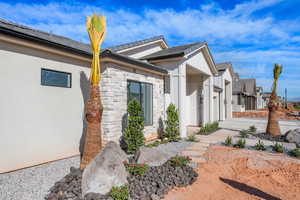 View of side of property featuring stone siding, a residential view, board and batten siding, and stucco siding