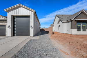 View of side of home with board and batten siding, driveway, and a tiled roof