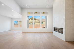 Unfurnished living room featuring recessed lighting, a fireplace, and light wood finished floors