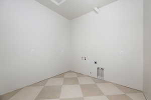 Laundry room with electric dryer hookup, light flooring, and washer hookup