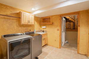 Laundry area featuring cabinet space, light tile patterned floors, washing machine and clothes dryer, a textured ceiling, and recessed lighting