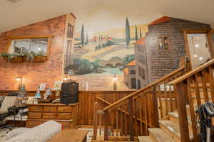 Stairway featuring lofted ceiling