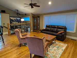 Living area with vaulted ceiling, light wood-type flooring, and ceiling fan