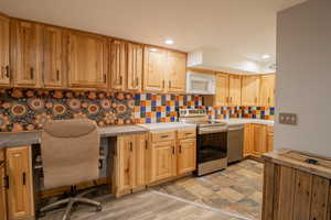 Kitchen featuring decorative backsplash, appliances with stainless steel finishes, light brown cabinets, and recessed lighting